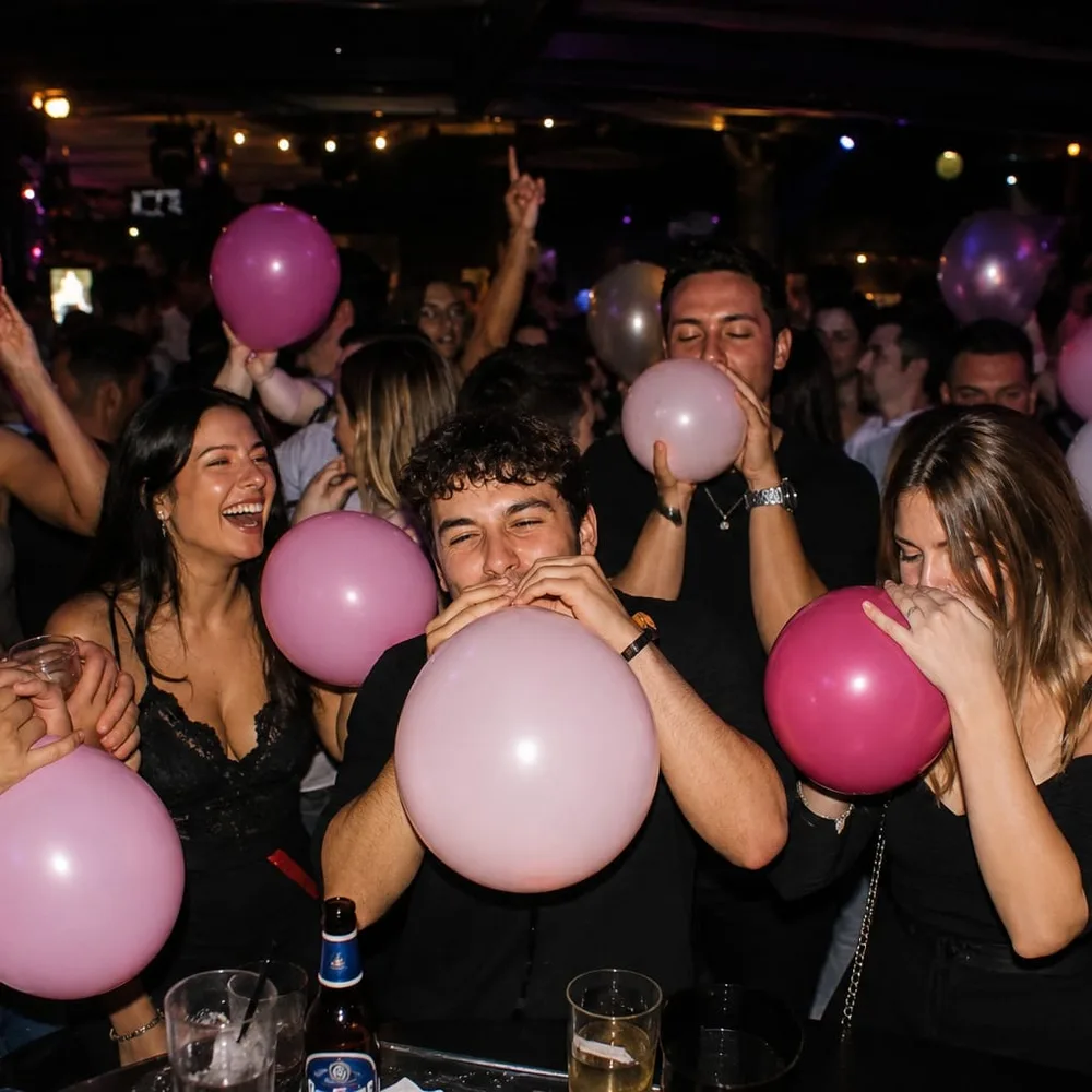Adults at a nightlife event holding pink balloons